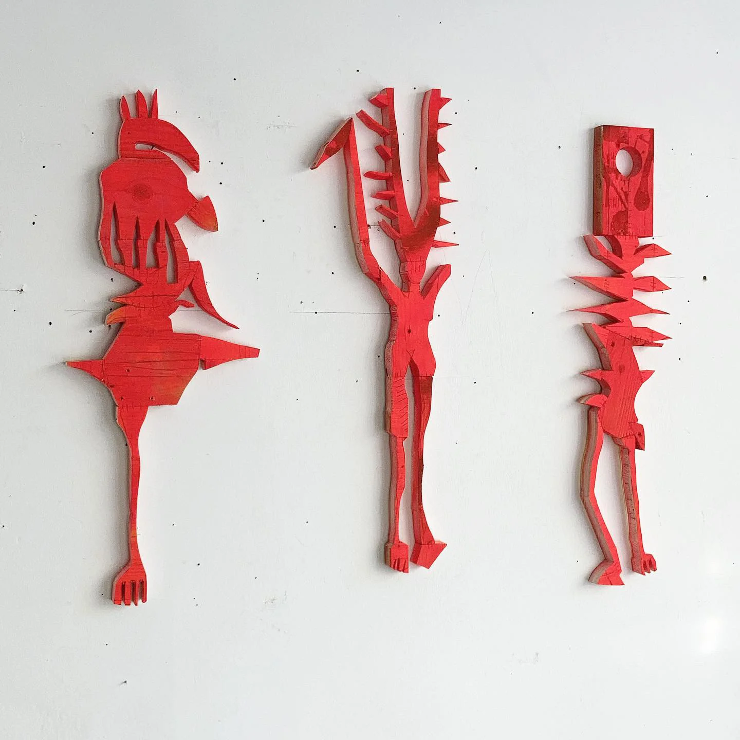 Wall installation of painted wood figures by Ernst Koslitsch, Art Brussels 2022