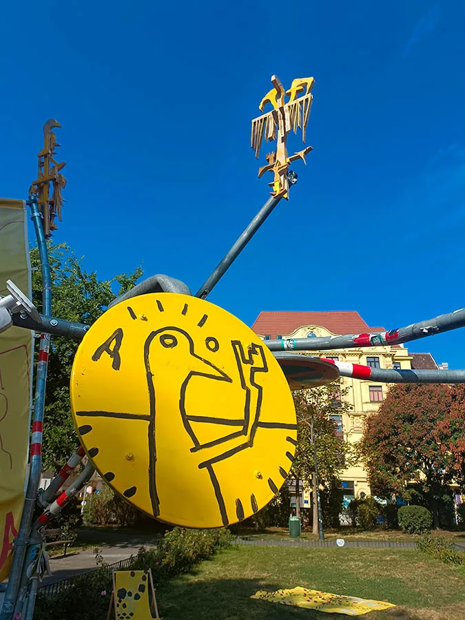 Detail of the Yellow Universe bird sculpture and painted parking sign, Aumannplatz, Vienna, Ernst Koslitsch