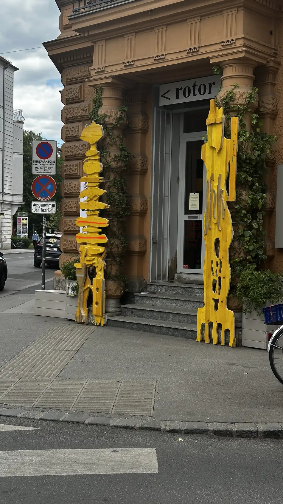 Echo Keepers 1 + 2 flanking the street-corner entrance of rotor, Graz