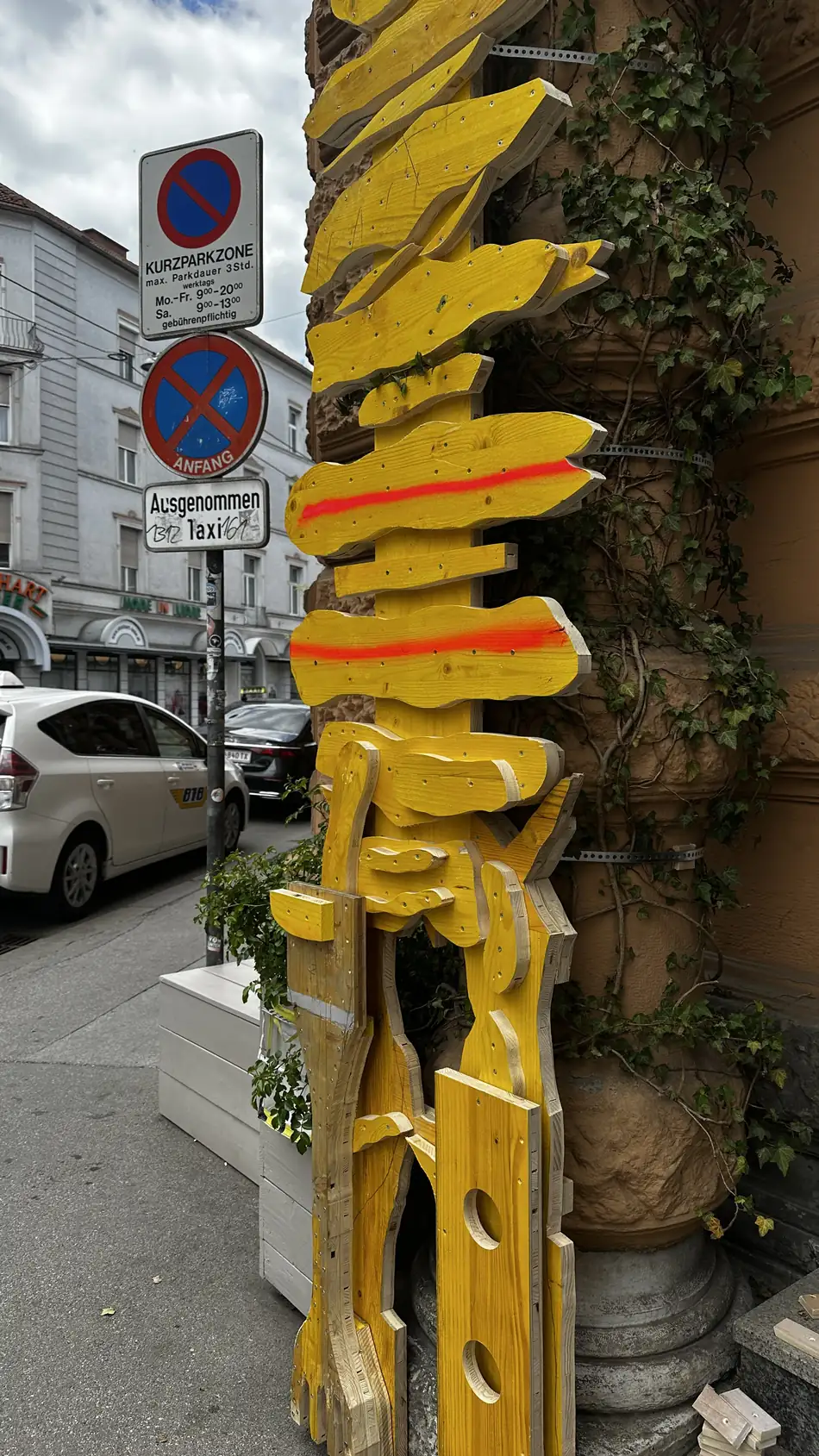 Echo Keeper sculpture by Ernst Koslitsch against an ivy-covered column at the entrance of rotor, Graz