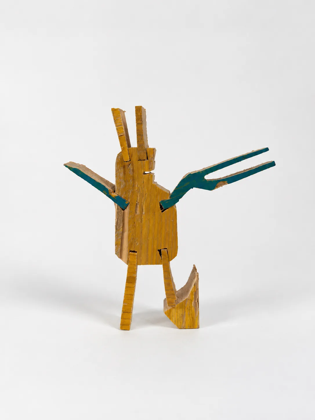Single yellow painted wood cutout figure with teal wing-like arms on a plain background, Ernst Koslitsch