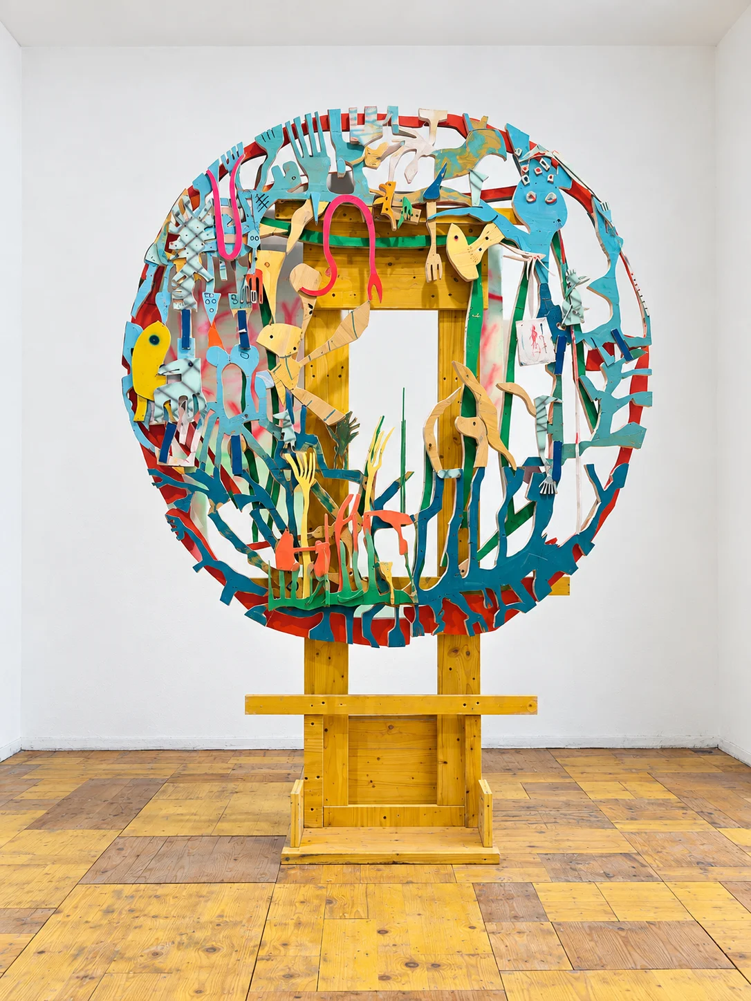 Large circular Yellow Universe wall sculpture on a wooden stand in the studio, Ernst Koslitsch