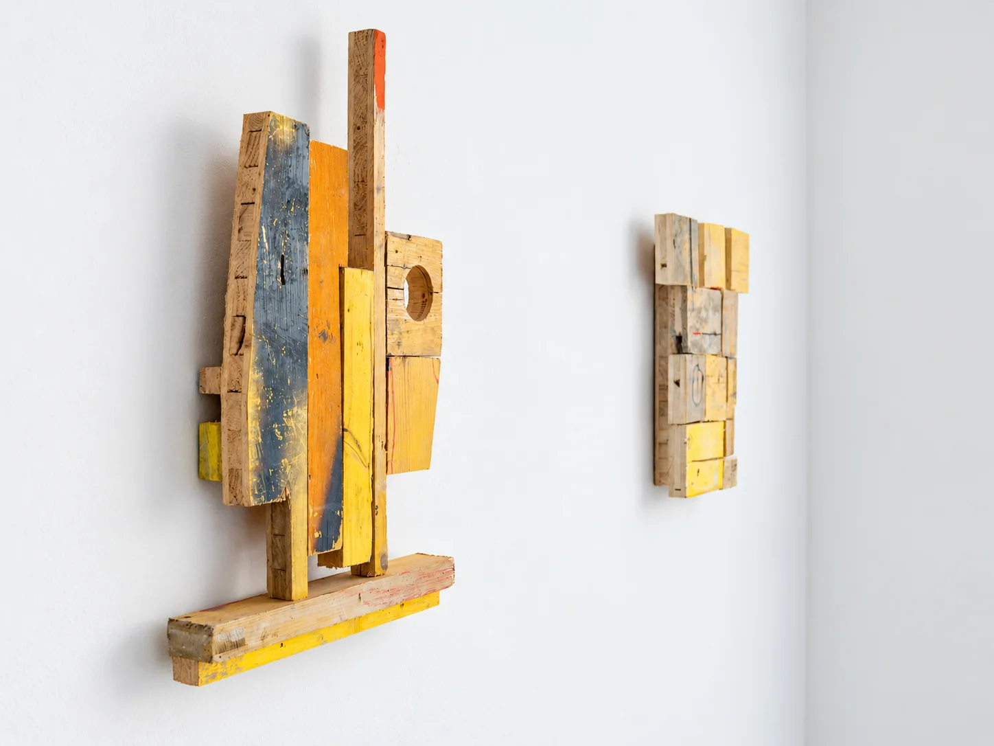 Grey, orange and yellow painted wood wall sculpture, studio view, Ernst Koslitsch