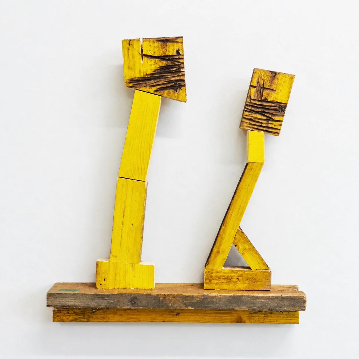 Two simple yellow wood standing figures, studio view, Ernst Koslitsch