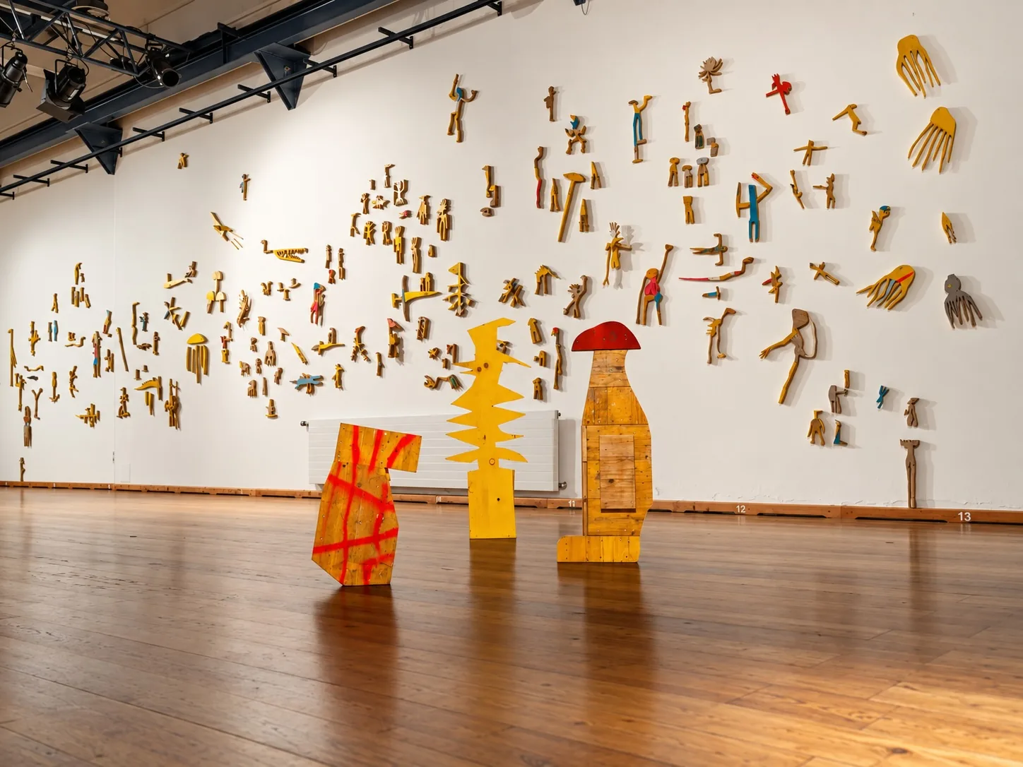 Wall installation view of TRANSFER at Kulturforum Laßnitzhaus, Deutschlandsberg, with wood sculptures by Ernst Koslitsch and other artists
